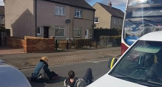سيدة تجلس على الأرض وتعطل المرور لخلافها مع سائق باص