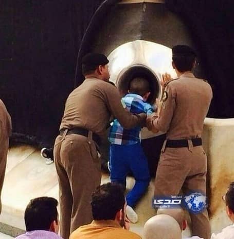 رجلا أمن بالحرم يحملان طفلاً معاقاً محققين أمنيته بتقبيل الحجر الأسود