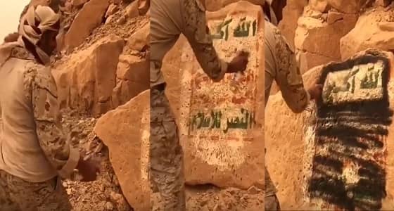 بالفيديو.. أحد الجنود البواسل يُزيل شعار الشيعة من صخرة باليمن