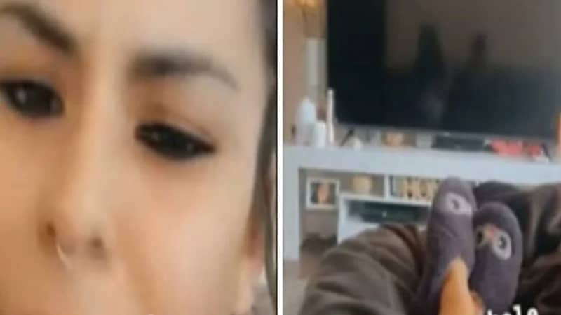 فتاة تصور شبحًا يجلس بجانبها أمام التلفزيون