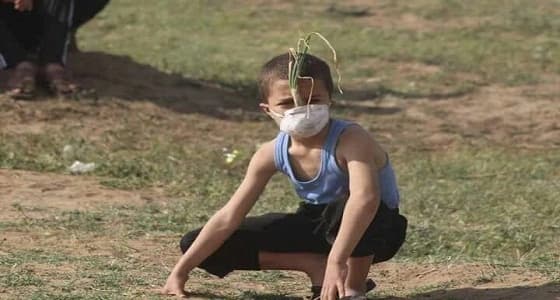 طفل فلسطيني يستخدم " بصلة " ليحمي نفسه من قنابل الغاز