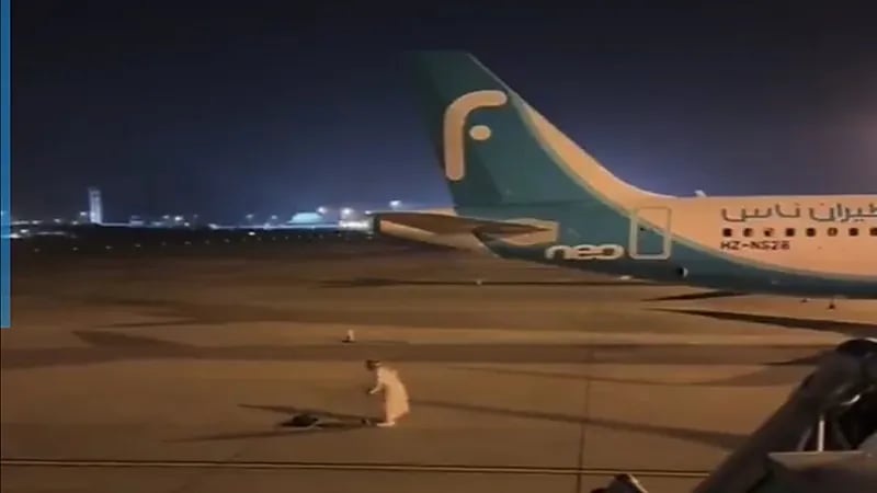 شخص يصلي في مدرج الطائرات وموظفة تقاطعه .. فيديو