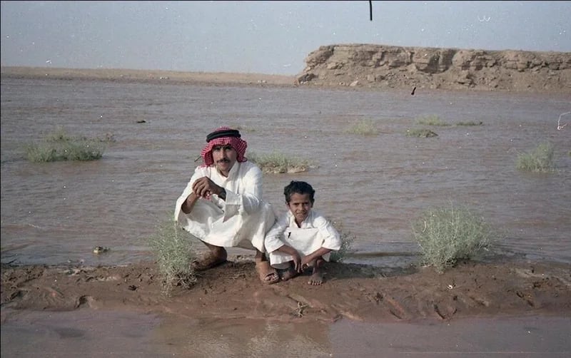 طفل وأبيه وسط جريان وادي الرمة بالقصيم قبل 40 عام