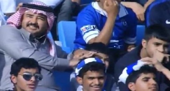 أب يظلل ابنه من أشعة الشمس خلال مباراة الهلال وأحد