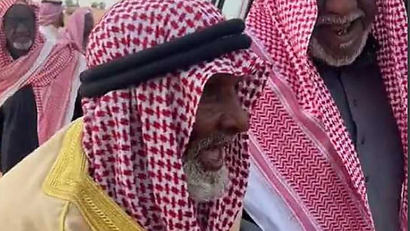 مشهد من التاريخ لشيوخ يركبون سيارة كلاسيكية بحضور مجموعة من القطع التراثية