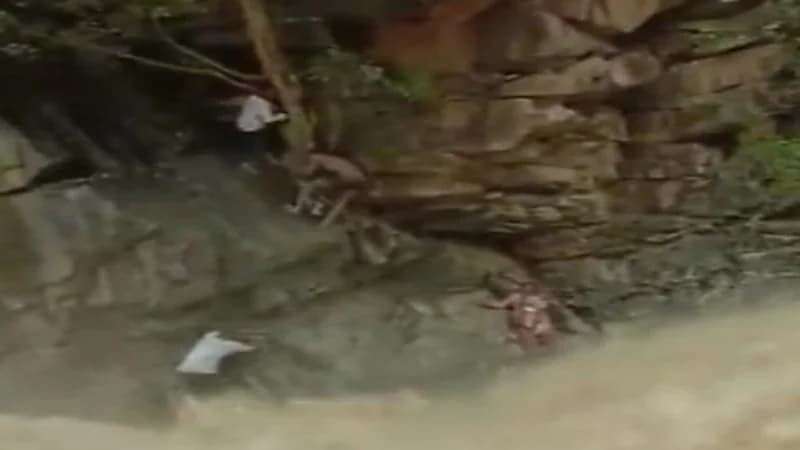 شاهد.. لحظة إنقاذ سيدة محاصرة مع طفلها بسبب تدفق شلالات