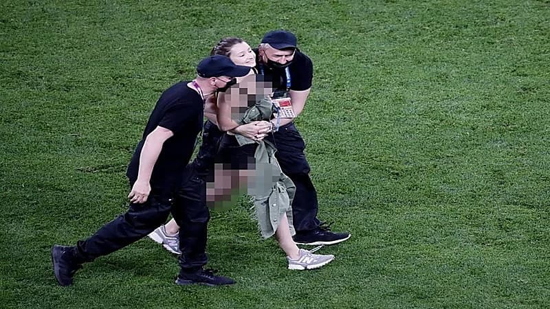 بالصور.. اقتحام فتاة لملعب مباراة بلجيكا وفنلندا للترويج لعملة رقمية